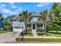 Charming two-story blue home features a welcoming front porch, well-manicured lawn, and two-car garage at 1325 Whisker Pole Ln, Mount Pleasant, SC 29466