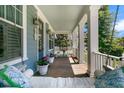 Inviting front porch with a cozy swing, decorative plants, and classic white columns at 1325 Whisker Pole Ln, Mount Pleasant, SC 29466