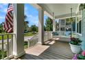 Relaxing front porch with a comfortable swing, American flag, and beautiful view of the neighborhood at 1325 Whisker Pole Ln, Mount Pleasant, SC 29466