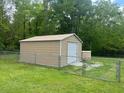 Exterior of the large, metal storage shed with roll-up door in fenced backyard at 136 Gailmoor Dr, Ladson, SC 29456
