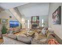 Open living room with vaulted ceilings, a stone fireplace, and a large sectional sofa, perfect for entertaining at 141 Bridgecreek Dr, Goose Creek, SC 29445