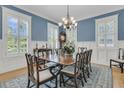 This bright dining room features wainscoting, stylish chandelier, and many windows with plantation shutters at 1531 Capel St, Mount Pleasant, SC 29466