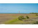 Beautiful view showcasing the marsh with a lighthouse in the distance on a sunny day at 1676 E Ashley Ave, Folly Beach, SC 29439