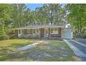 Inviting brick home featuring a well-kept front yard and a convenient attached garage at 2645 Mona Ave, Charleston, SC 29414