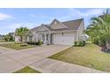 Beautiful one-story home showcasing a two-car garage, lush landscaping, and inviting front entrance at 315 Fish Creek Ct, Summerville, SC 29486
