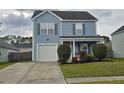 Light-blue, two-story home with blue shutters, an attached garage, and manicured landscaping at 328 Bradley Bend Dr, Moncks Corner, SC 29461