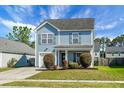 Charming two-story home features light-blue siding, manicured lawn, and attached garage at 328 Bradley Bend Dr, Moncks Corner, SC 29461