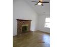 Open-concept living room with a brick fireplace, ceiling fan, and hardwood flooring at 4153 Hickory Ln, Ladson, SC 29456