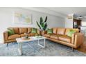 Modern living room featuring tan leather couches, a bright abstract painting, and stylish, sophisticated decor at 4979 Lake Palmetto, North Charleston, SC 29418