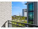 Balcony view of the city skyline with green space, buildings, and distant bridge over the water at 5 Gadsdenboro St # 416, Charleston, SC 29401