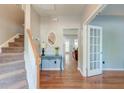 Bright foyer with hardwood floors, staircase, decorative table, and an open doorway to the living area at 5400 Rock Creek Ct, North Charleston, SC 29420
