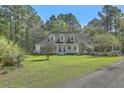Charming exterior view of the home with a sprawling front yard at 5950 Lowell Reed Rd, Ravenel, SC 29470