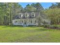 Inviting home with a covered front porch, set amidst mature trees at 5950 Lowell Reed Rd, Ravenel, SC 29470