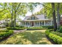 Attractive home with a wide front porch, complemented by mature trees and green lawn at 707 Royall Ave, Mount Pleasant, SC 29464