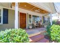 Inviting front porch featuring a wooden ceiling, exposed brick steps and classic wooden chairs at 905 Simmons St, Mount Pleasant, SC 29464