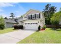 Inviting two-story home with a spacious driveway, well-kept lawn, and a convenient two-car garage at 9660 Godwin St, Ladson, SC 29456