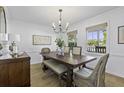 Elegant dining room with a wooden table, chandelier, and natural light from the windows at 99 Shadowmoss Pkwy, Charleston, SC 29414