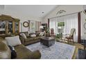 Inviting living room featuring hardwood floors, vaulted ceilings, and a comfortable brown leather sofa at 106 Pickering Ln, Charleston, SC 29414