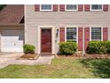 Inviting front entrance with a red door, manicured landscaping, and charming details at 109 E Hartwick Ln, Goose Creek, SC 29445