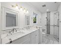 Bright bathroom featuring double sinks, marble countertops, and glass-enclosed shower with unique tiling at 109 Red Cypress Dr, Goose Creek, SC 29445