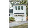 Attached garage with carriage doors and lantern sconces on a well-manicured lot at 1106 Meadowcroft Ln, Mount Pleasant, SC 29464