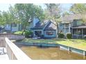 Scenic view of a waterfront home with a patio overlooking a tranquil pond and bridge at 1136 Shadow Lake Cir # 54, Mount Pleasant, SC 29464