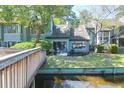 Waterfront home featuring a patio, lush lawn, and tranquil views of the water from the bridge at 1136 Shadow Lake Cir # 54, Mount Pleasant, SC 29464