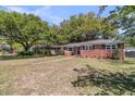 Attractive brick home with mature trees, a well-kept lawn, and a welcoming exterior at 1142 Camden St, North Charleston, SC 29405