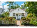 Charming cottage-style home with a picket fence and blooming pink roses bordering the walkway at 115 Peachtree St, Charleston, SC 29403