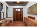 Bright entryway with terracotta floors, wooden bench and a striking wooden front door at 1153 King St, Charleston, SC 29403