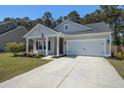 Inviting single-story home featuring a well-kept lawn, concrete driveway and covered porch with an attached two-car garage at 117 Camellia Bloom Dr, Moncks Corner, SC 29461