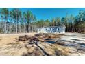 Charming single-story home featuring grey siding, white shutters, and a neatly landscaped front yard at 1576 Pine Grove Rd, Ruffin, SC 29475