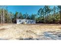 Charming single-story home featuring grey siding, white shutters, and a neatly landscaped front yard at 1576 Pine Grove Rd, Ruffin, SC 29475