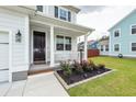 Inviting front porch with white columns, decorative plants, and manicured landscaping at 158 Boots Branch Rd, Summerville, SC 29485