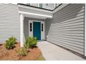 Close-up of a vibrant blue front door with sidelights and white trim, framed by lush landscaping at 168 Keaton Brook Dr, Summerville, SC 29485