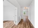 Hallway with hardwood floors, white walls, french doors and view to a bright adjacent room at 1728 Refuge Dr, Ladson, SC 29456