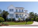 Charming two-story home with landscaped yard, inviting front porch, and a classic white exterior with gray trim at 1905 Lone Oak Pt, Mount Pleasant, SC 29466