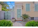 Welcoming entrance with a teal door, black iron gate, and lush landscaping at 197 Coming St, Charleston, SC 29403