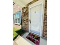Inviting townhouse entrance with white door, brick facade, and 'Welcome' mat at 2040 Rondo St # H, Charleston, SC 29414
