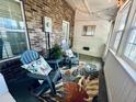Cozy enclosed porch with comfortable seating, stylish rug, and brick accents at 2040 Rondo St # H, Charleston, SC 29414