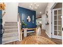 Stylish entryway with blue accent wall, wooden bench, and elegant staircase at 206 Red Bluff St, Summerville, SC 29483