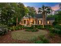 Beautiful brick home with lush landscaping, palm trees, and well-maintained lawn at 207 Central Ave, Summerville, SC 29483