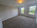 Spacious bedroom with carpet flooring and two windows providing natural light at 209 Killarney Trl, Moncks Corner, SC 29461