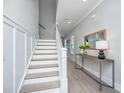 Well-lit staircase with white risers and handrail, complemented by stylish gray walls and hardwood floors at 2282 Braided Ln, Mount Pleasant, SC 29466