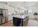 An open concept kitchen featuring white cabinets, stainless appliances, and a large center island with seating at 2568 Helmsman Rd, Johns Island, SC 29455