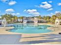 Large community pool with ample decking, offering a refreshing retreat surrounded by beautiful landscaping and palm trees at 2889 Backman St, Mount Pleasant, SC 29466