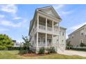 Inviting two-story home with double porches, classic columns, and well-maintained landscaping, offering timeless appeal at 2906 Quarterdeck Ct, Mount Pleasant, SC 29466