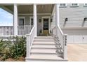 Welcoming front porch with white railings and columns, leading to a stylish front door and a two-car garage at 2906 Quarterdeck Ct, Mount Pleasant, SC 29466