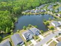 Aerial view of a residential community by the lake surrounded by lush trees and well manicured lawns at 3149 Timberline Dr, Johns Island, SC 29455