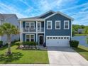 Beautiful two-story blue house has a porch on the second level and a well maintained lawn with an attached two-car garage at 3149 Timberline Dr, Johns Island, SC 29455